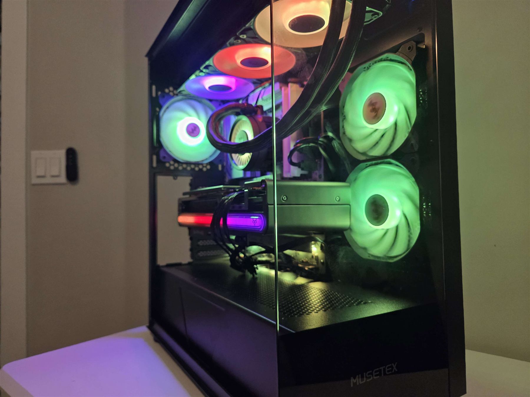 Custom black RGB gaming PC with liquid cooling and green ring fans